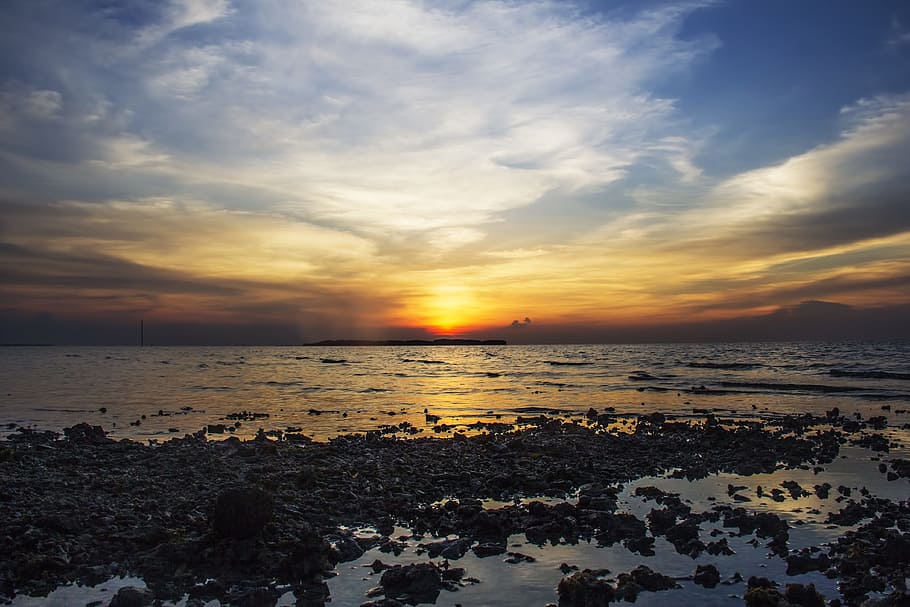 stone near shoreline under cloudy sky, beach, sunset, rocks HD wallpaper