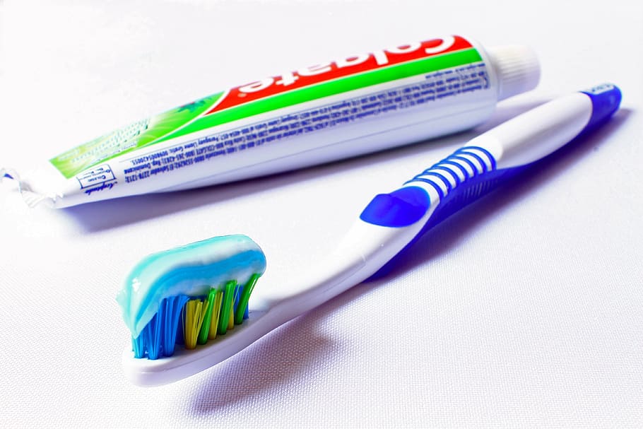 Colagate and toothbrush on white surface, hygiene, oral hygiene