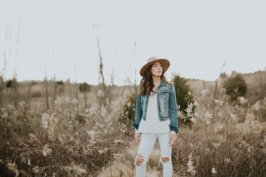 woman in blue denim jacket surrounded by grass during daytime, woman standing on wheat field under gray sky, HD wallpaper