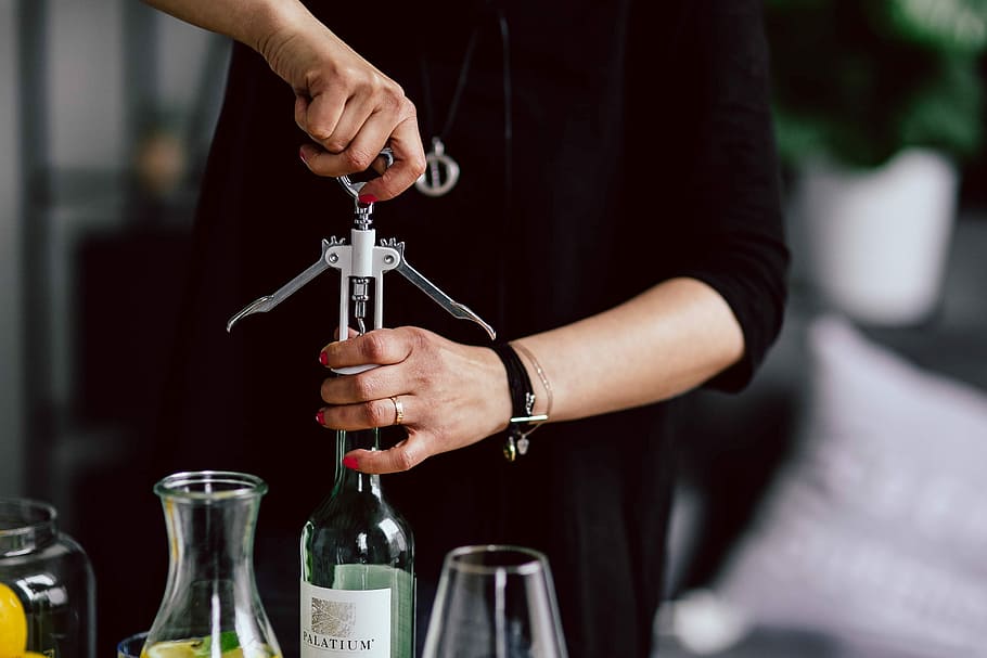 Hands opening wine bottle with corkscrew, female, woman, alcohol