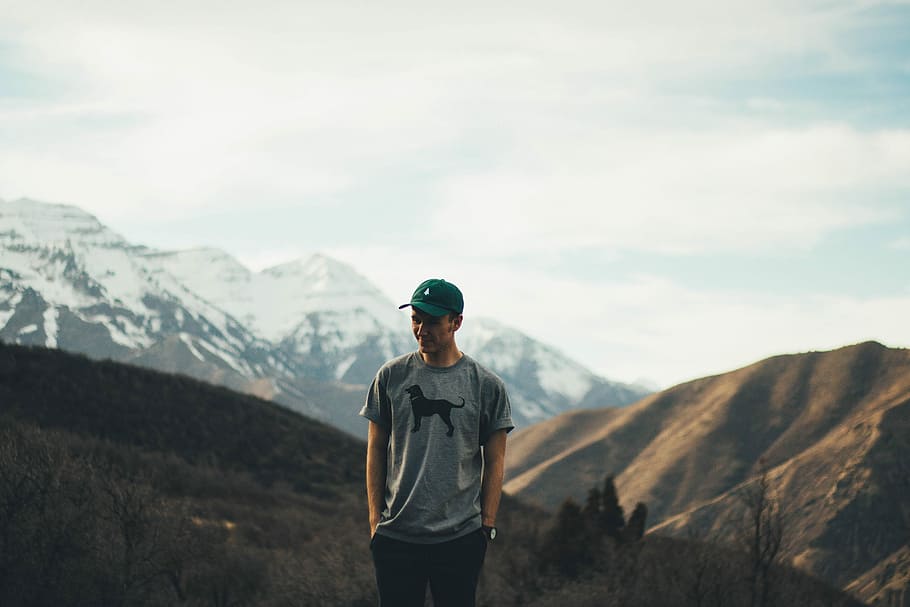 man standing on mountain range, man standing with hands in pocket on mountain peak HD wallpaper