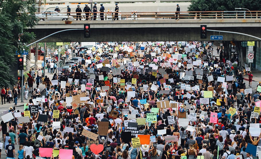 group of people performing rally on street under the bridge during daytime HD wallpaper
