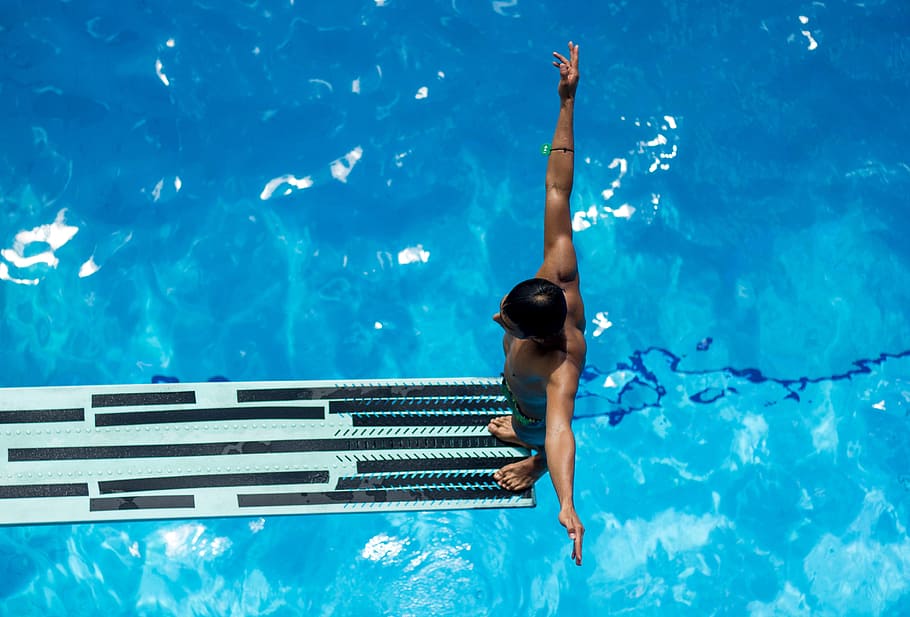 view of a man about to jump from a plank down to a pool, swimming HD wallpaper