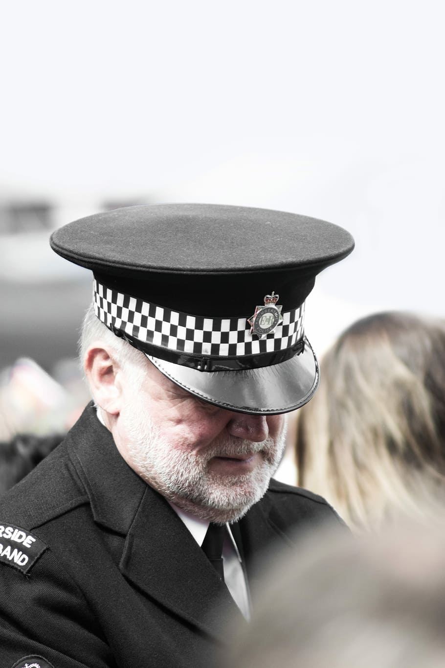 police man wearing white and black peak hat, man in black peak cap selective-focus photography