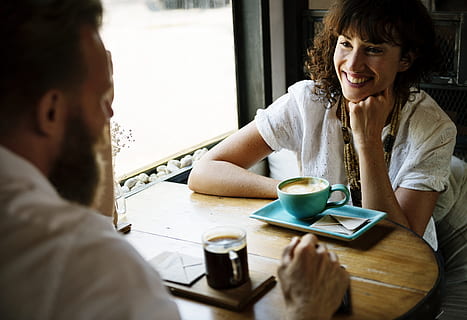 man and woman dating while smiling at eachother, cup, restaurant HD wallpaper