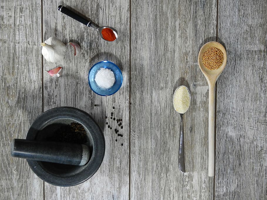round black mortar and pestle near brown wooden ladle with powder HD wallpaper