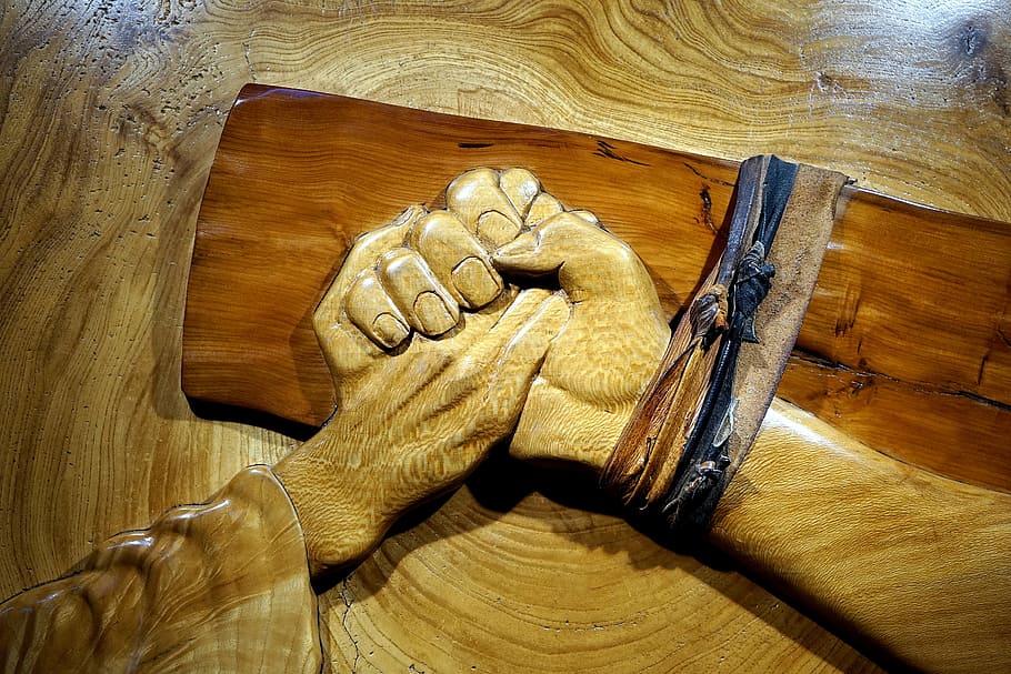 shallow photography of carved wood holding hands, religious, carvings