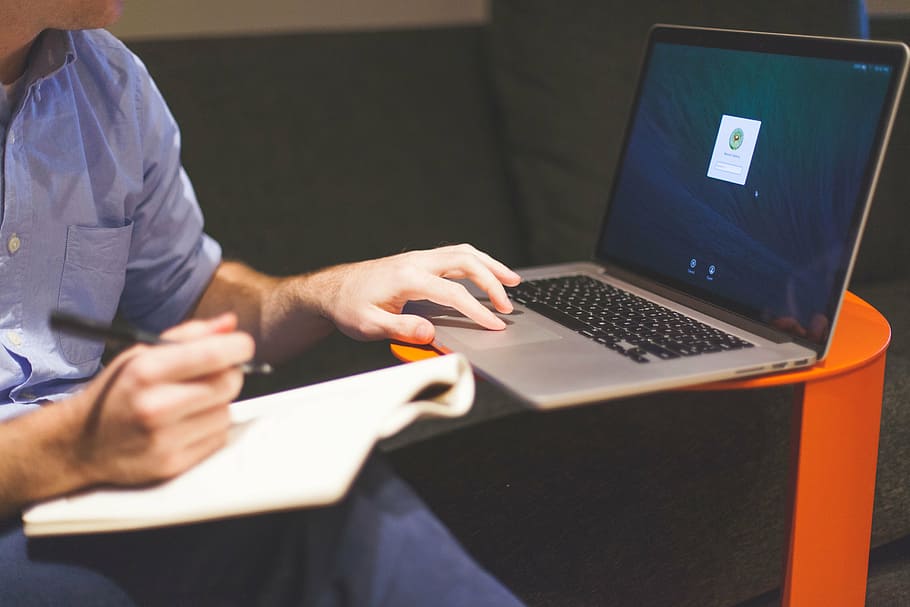 man sitting down while using MacBook Pro, person, navigating HD wallpaper