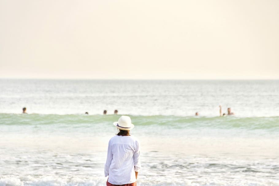 person with hat standing front of sea at daytime, woman standing in front of sea HD wallpaper