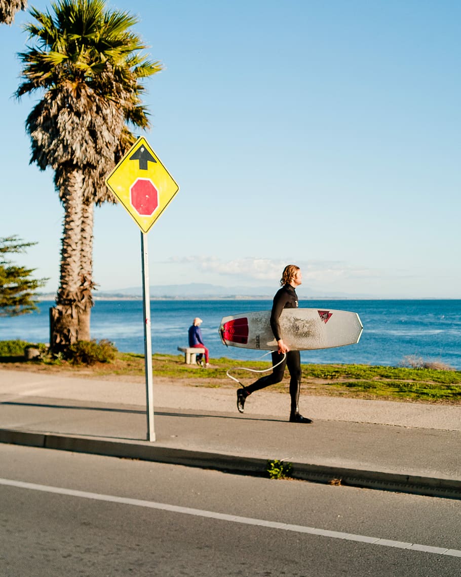 man holding surfboard near beach, person holding white and red snowboard HD wallpaper