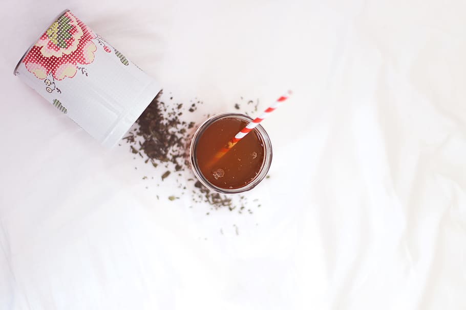 brown liquid with red and white straw, filled clear drinking glass with straw on white surface HD wallpaper