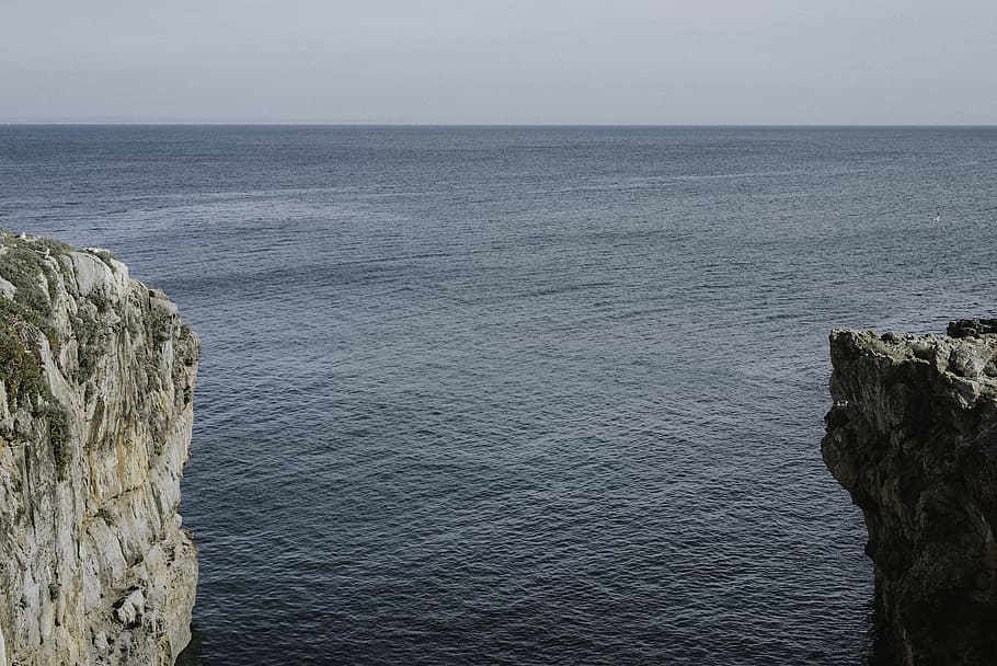 water between cliffs, gray rock near body of water, cloudy, sky HD wallpaper