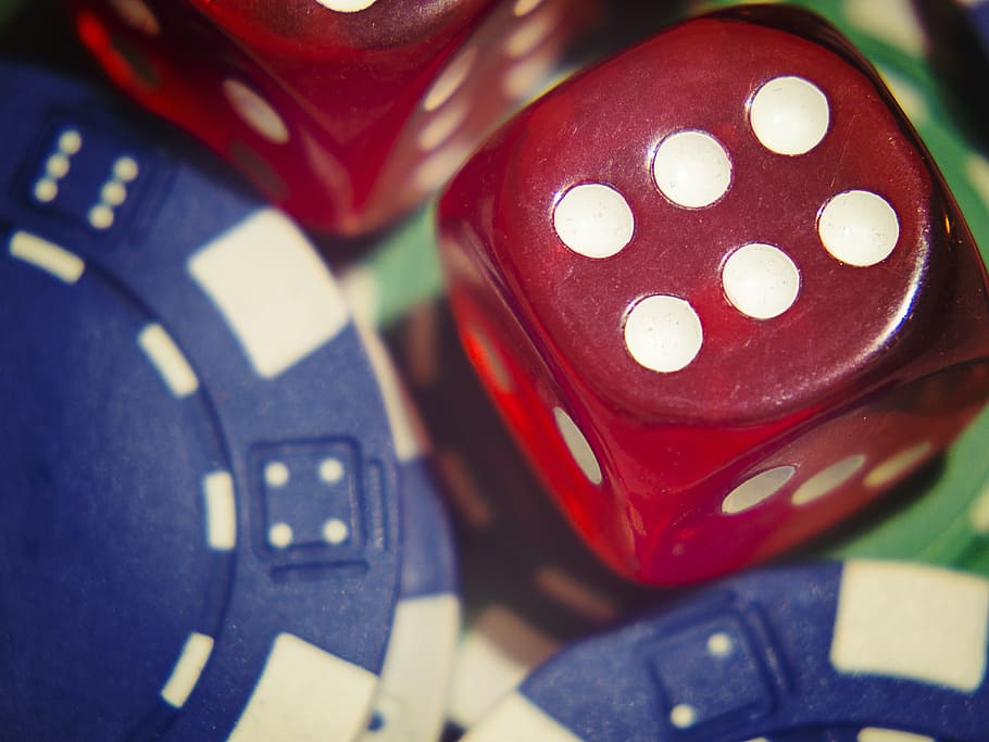 red dice and blue poker chips in closeup photography, gamble