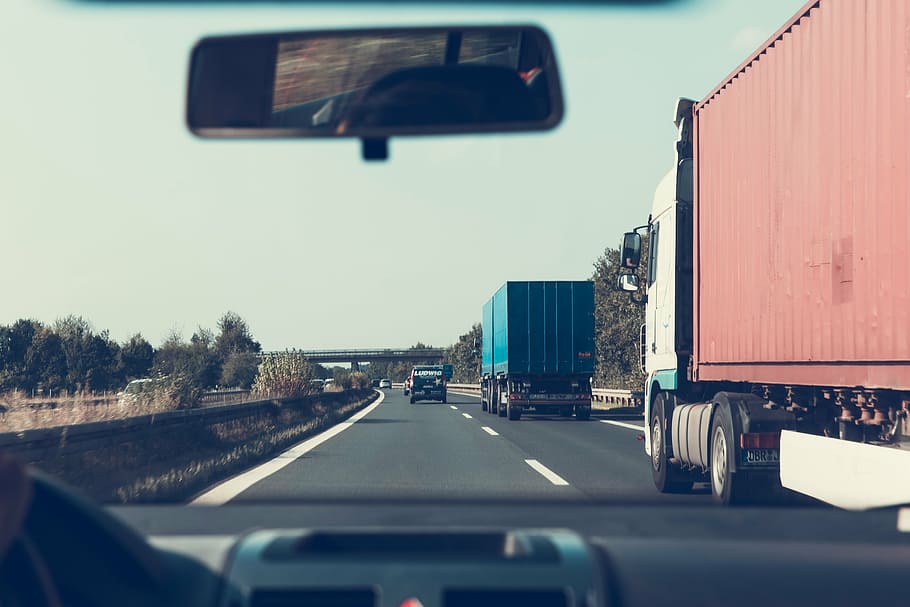 two freight trucks passing black van, road, grey, clouds, highway HD wallpaper