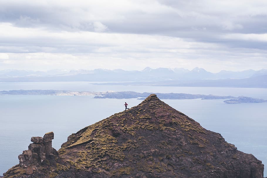 person walking on brown mountain, person standing atop of a mountain during day time HD wallpaper