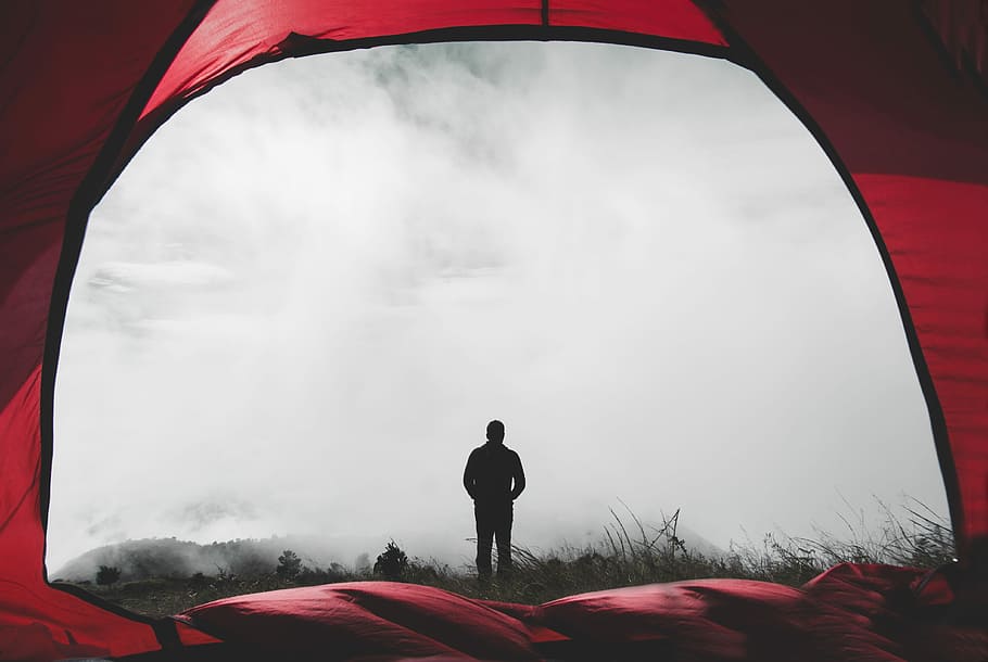man standing on grass field during misty day, photo of silhouette person standing covered with fog print tent HD wallpaper