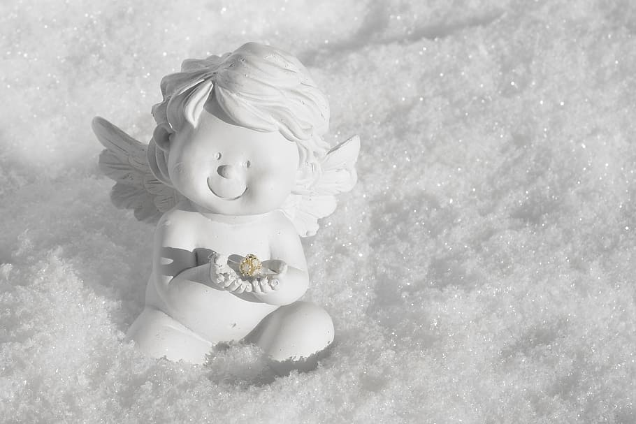 cherub white ceramic figurine sitting on the snow, angel, guardian angel