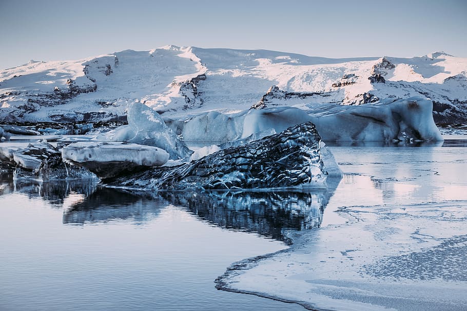 snowy mountains in middle of body of water, snow-covered shore HD wallpaper