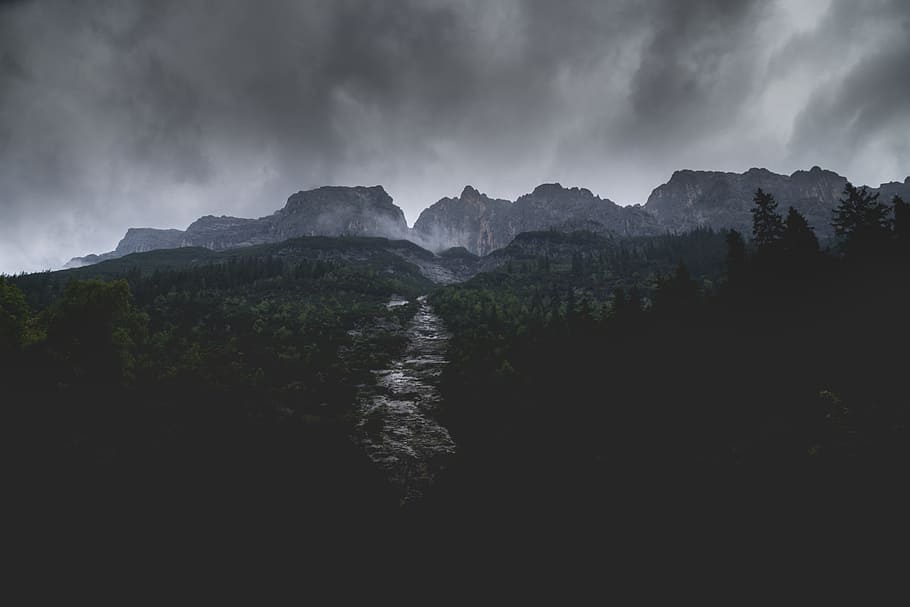 river between trees near mountain under gray clouds, forest near mountain range under cloudy sky HD wallpaper