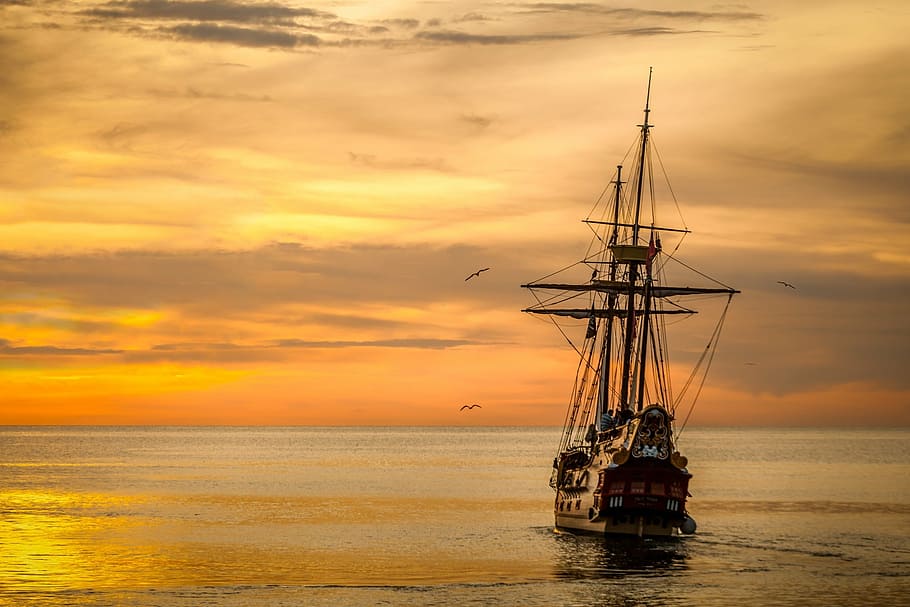 brown and black galleon ship on body of water at golden hour HD wallpaper