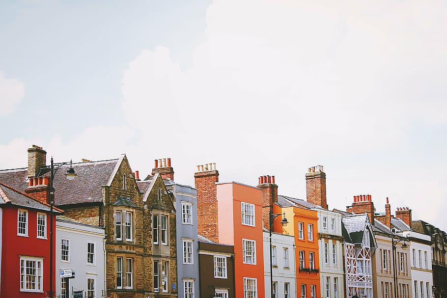 assorted-color concrete buildings under white clouds at daytime HD wallpaper
