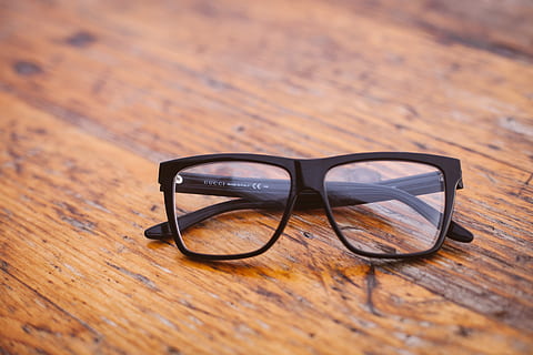 black framed Wayfarer-style eyeglasses on wooden surface, black framed eyeglasses on brown surface HD wallpaper