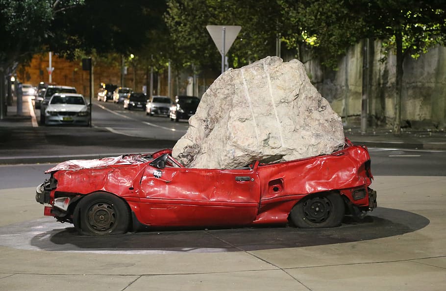 red car squashed by gray stone, crushed, art, modern, sculpture HD wallpaper