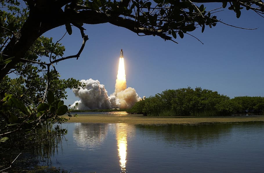space shuttle taking off near body of water, rocket, lift-off