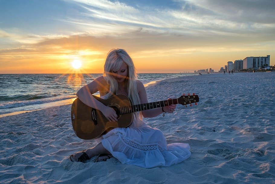 woman in white dress sitting on white sand while playing a guitar, HD wallpaper