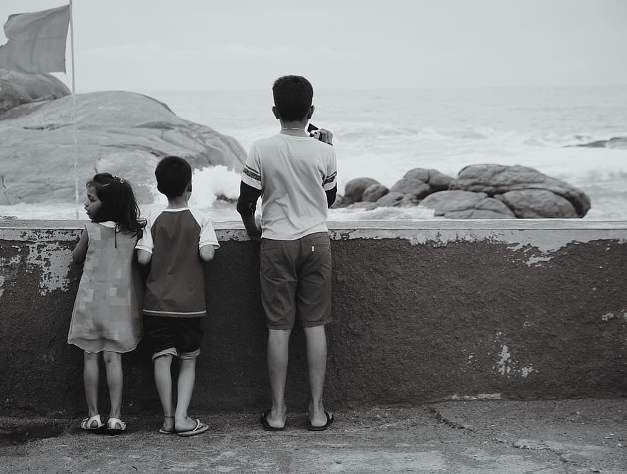 boy in white shirt near ocean, children, beach, siblings, black and white