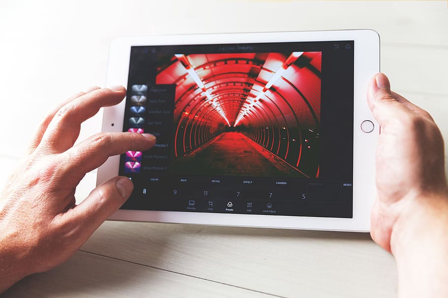 A man edits a photo in Lightroom photo app for iPad tablet computer HD wallpaper