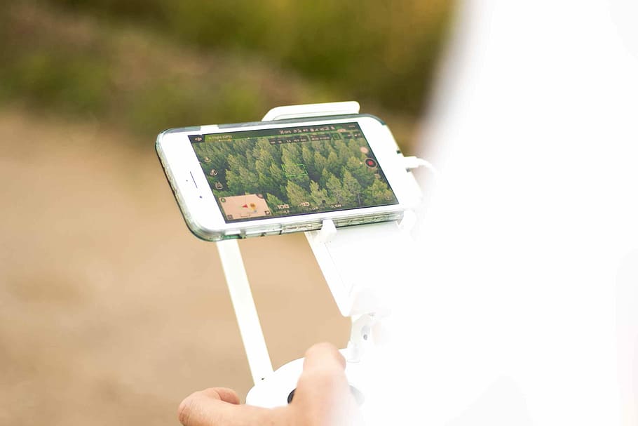 person looking at smartphone, person holding a drone controller HD wallpaper