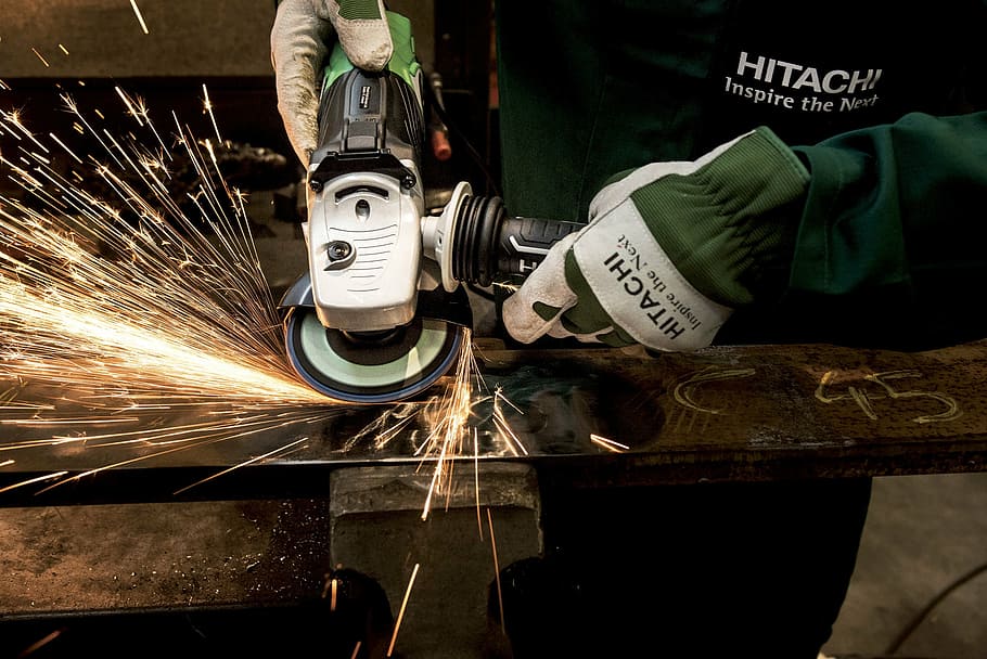 person using angle grinder on steel, hitachi, power tool, flexible