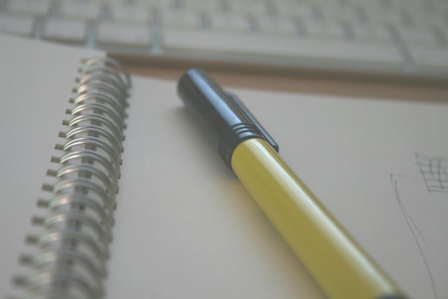 black ballpoint pen on white spiral book shallow focus photography HD wallpaper
