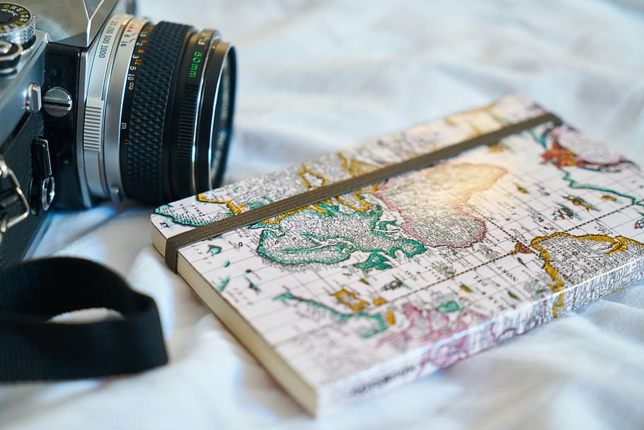 closeup photo of book on white textile beside the camera, old HD wallpaper