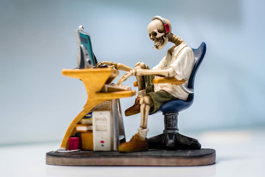 human skeleton sitting on chair in front table figure, Internet