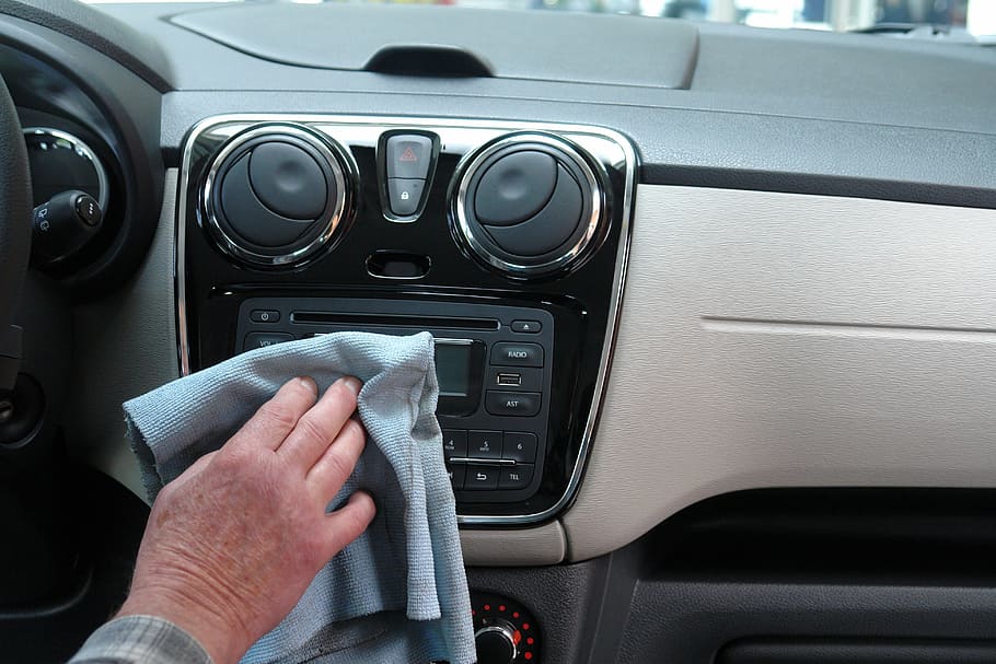 person wiping the car stereo of his car, auto, car wash, transport