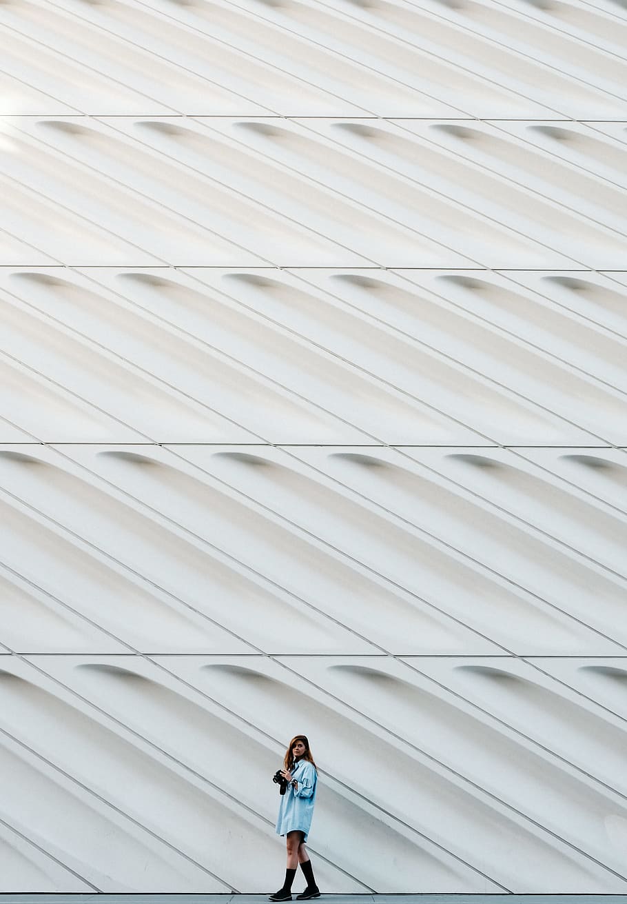 woman standing beside white concrete wall, man standing beside wall HD wallpaper