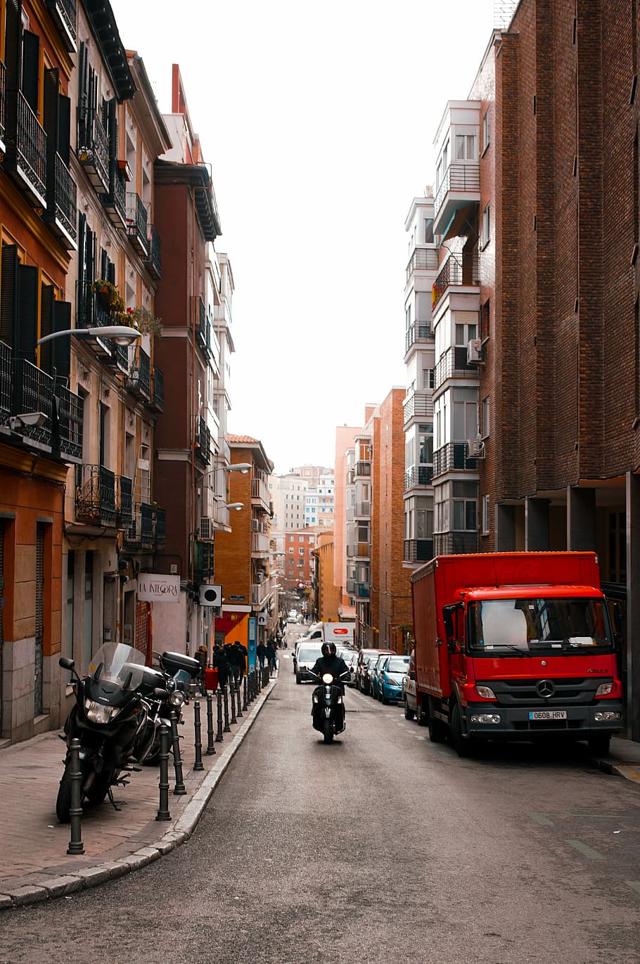 person riding motorcycle, man riding motorcycle between building HD wallpaper