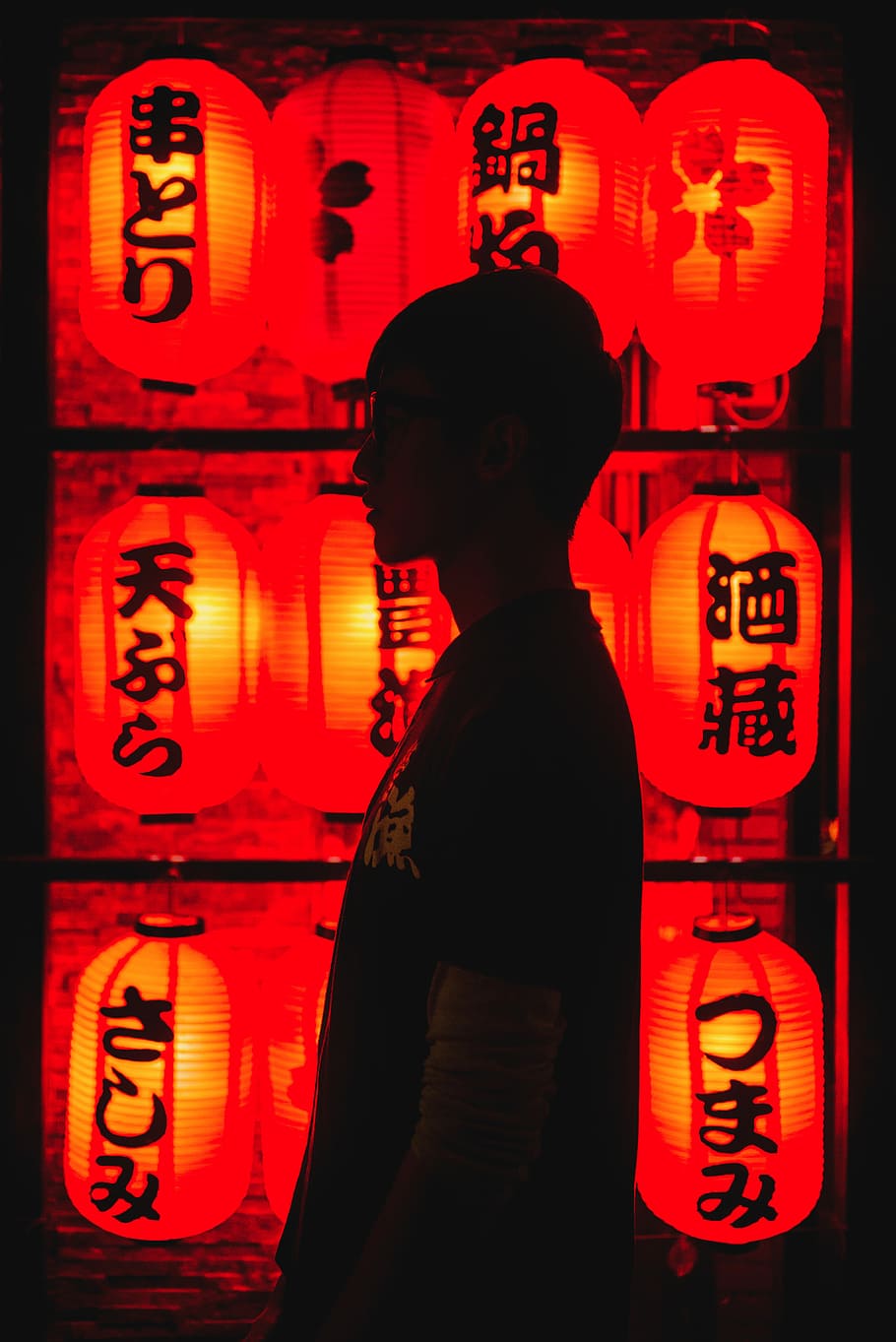man wearing black t-shirt in front of paper lamps, man's silhouette near red paper lamps HD wallpaper