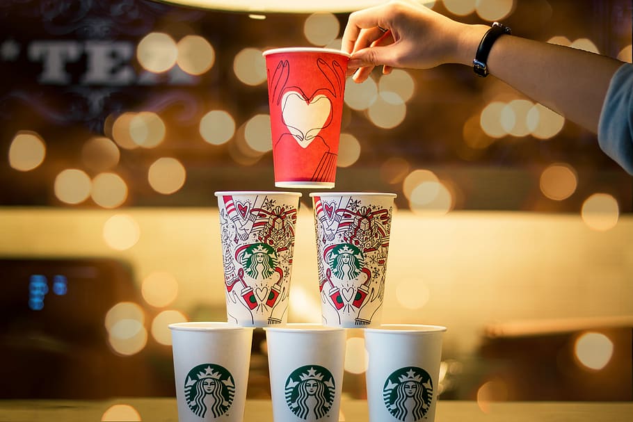person stacking five assorted-color Starbucks cups, person holding red disposable cap, HD wallpaper
