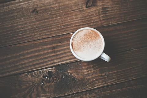 flat lay photography of a single cup coffee, white ceramic mug with coffee latte on brown wooden surface HD wallpaper