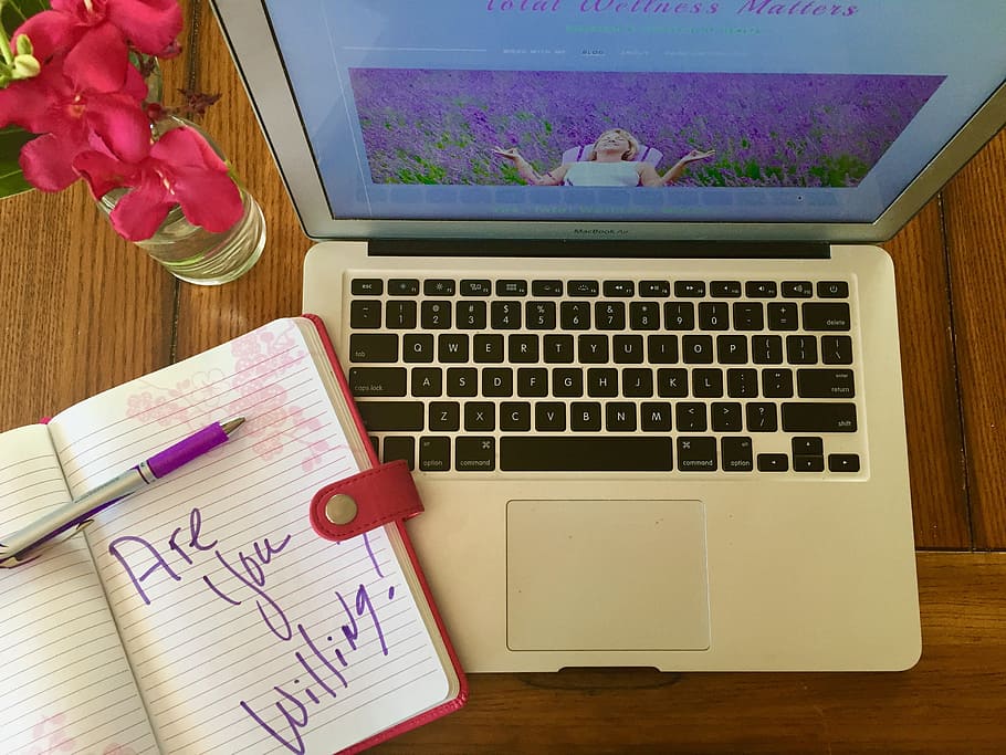 MacBook Air beside binder with purple pen, blogging, coaching HD wallpaper