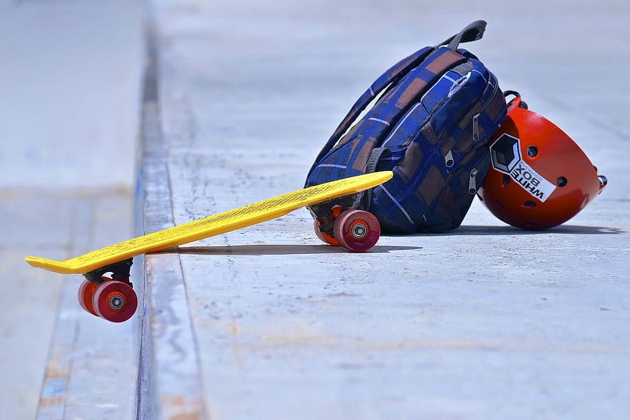 blue backpack, red skateboard helmet and yellow cruiser skateboard on gray concrete road, HD wallpaper