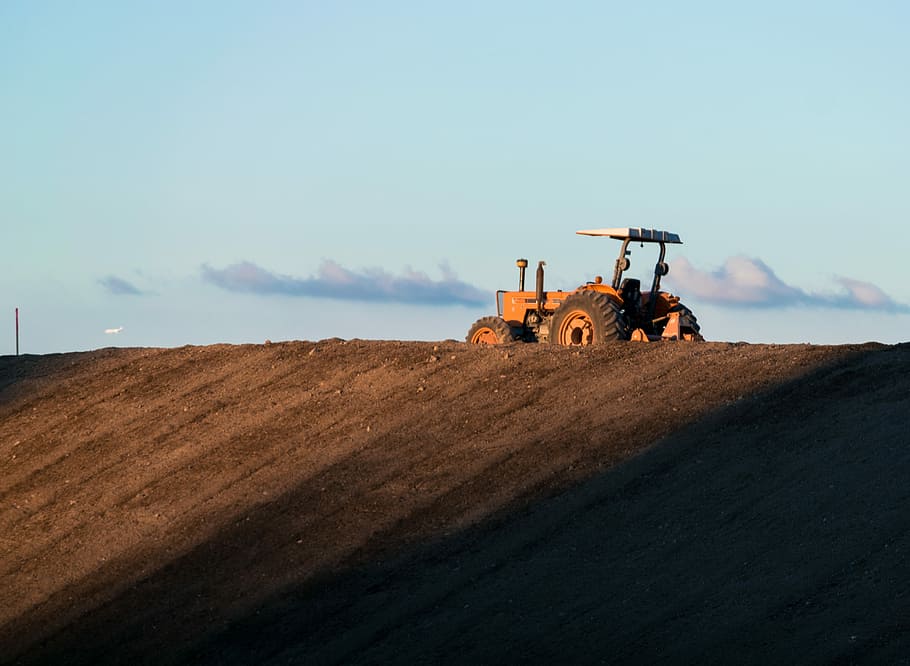 Sunset tractor in Tacoma Washington, orange tractor on the field HD wallpaper
