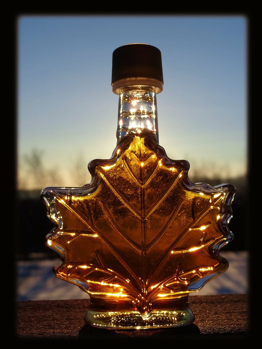 selective brown tinted glass leaf bottle at daytime, maple, syrup