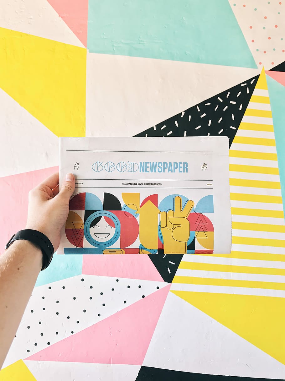 person holding newspaper article, person holding multicolored goodnewspaper HD wallpaper