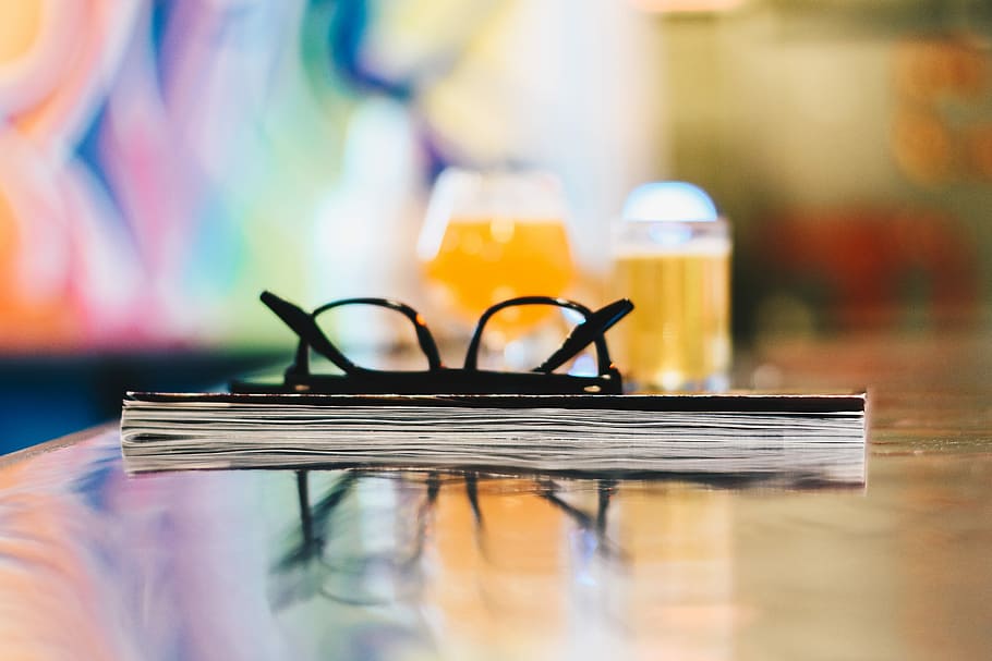 black eyeglasses on closed book on table selective focus photography, eyeglasses on book HD wallpaper