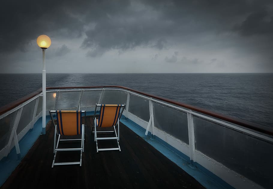 two brown and white folding chairs on boat surrounded by body of water under gray sky, two orange folding chairs inside yacht HD wallpaper