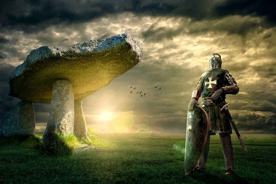 knight wearing gray metal armor standing on green grass, dolmen